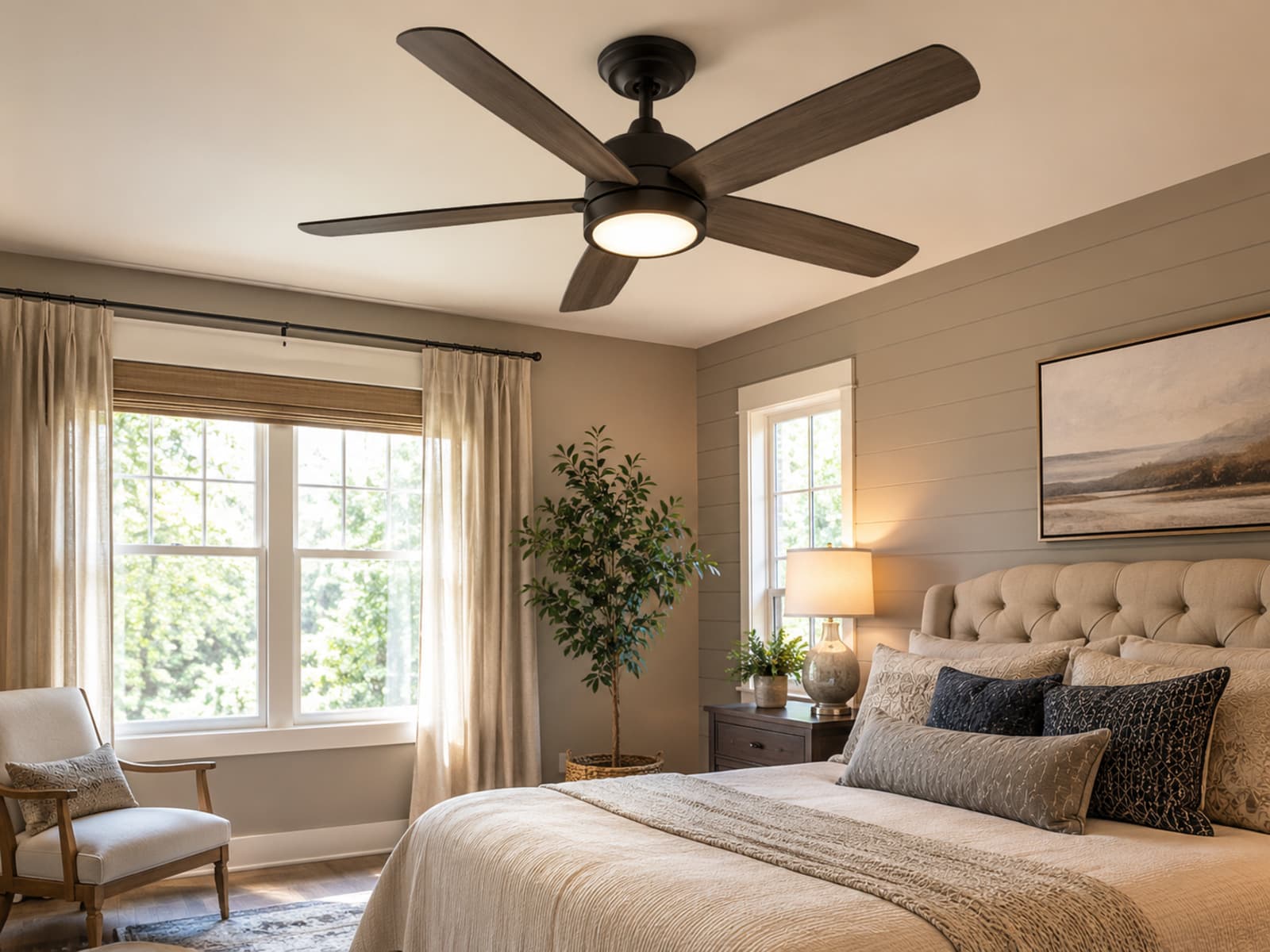 A five-blade ceiling fan with integrated light installed above a bed