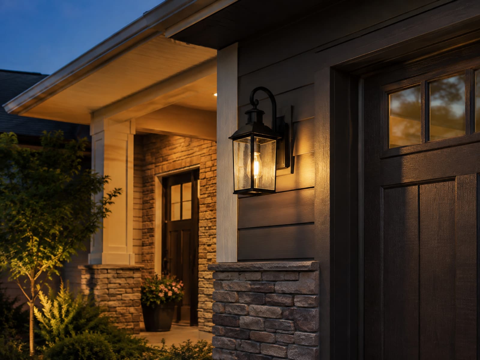 A newly added exterior wall light illuminating a home entry at dusk