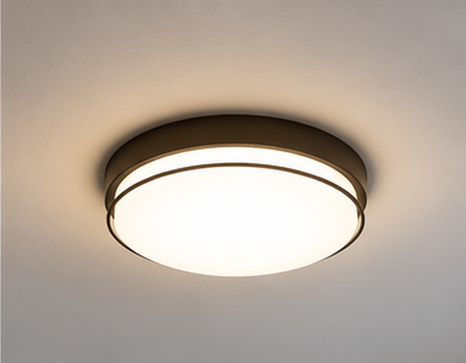 A round flush-mount ceiling light fixture lit against a ceiling