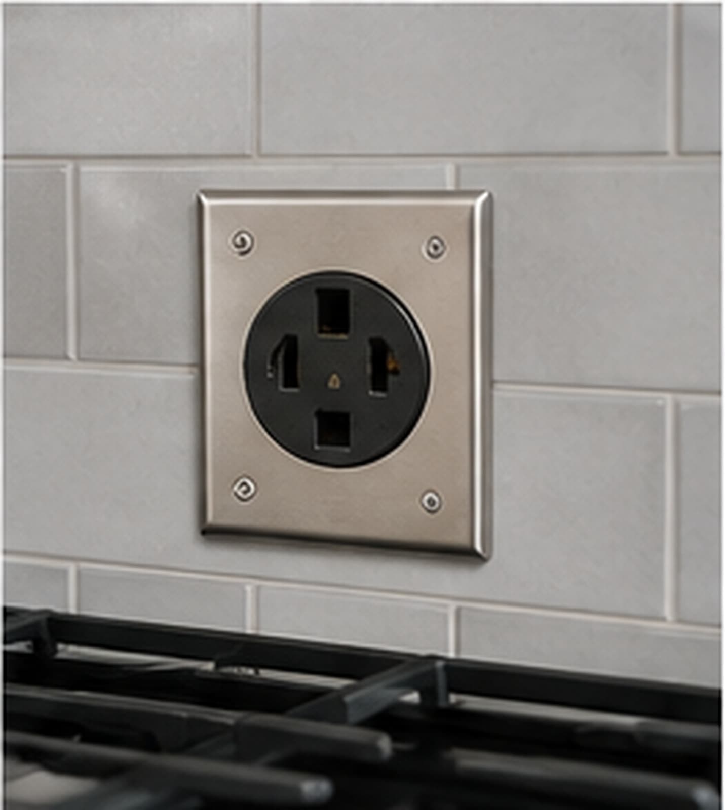 A 240V range receptacle on a tiled wall above a stove
